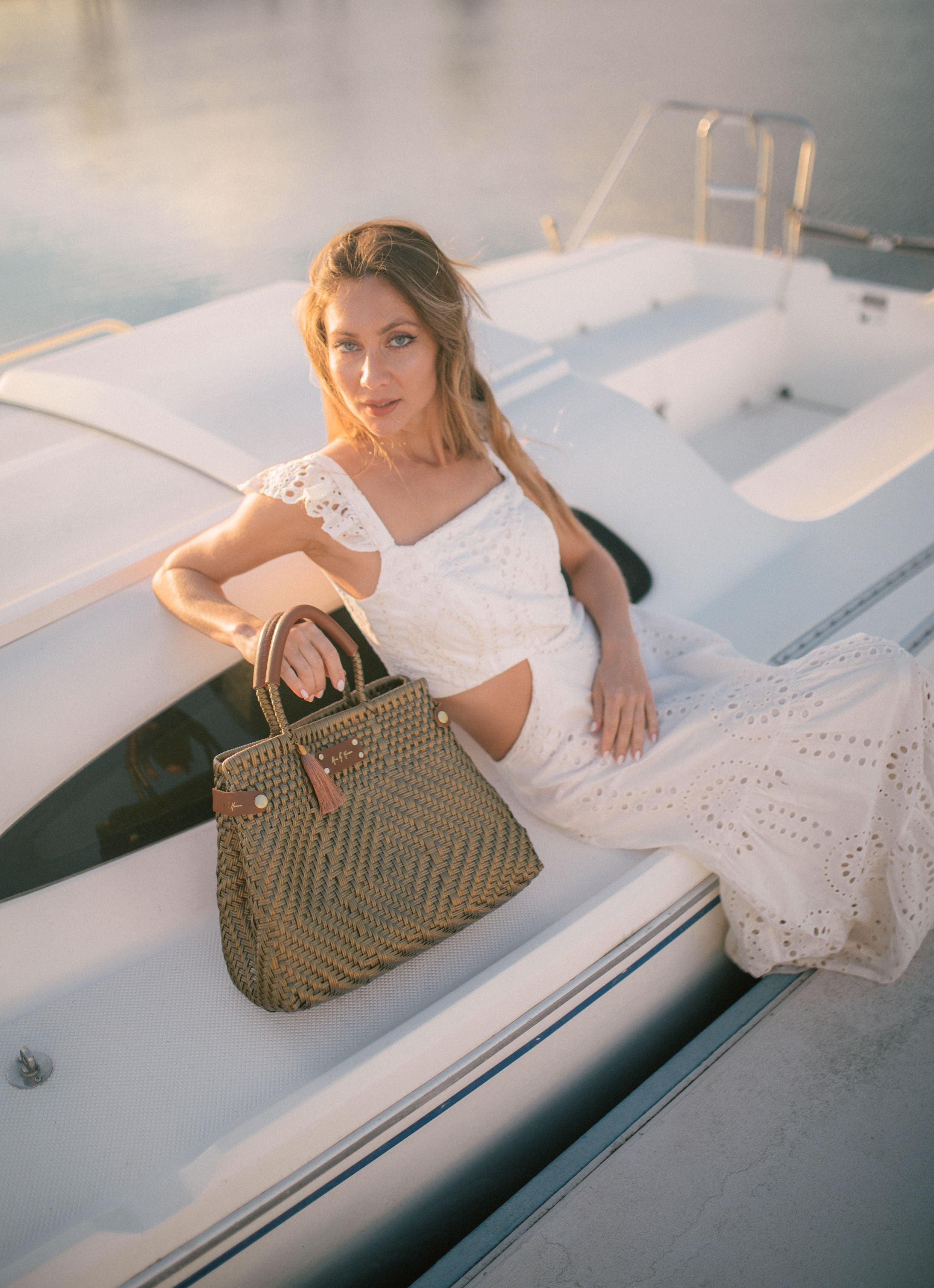 An eco-friendly, sustainable handbag in gold, featuring handles crafted from recycled leather.